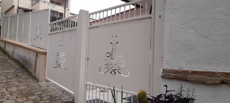 Cancelletto pedonale e recinzione bianchi con pannelli traforati a decoro